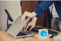 Person klappt Laptop auf