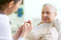 Ärztin spritzt ältere Patientin