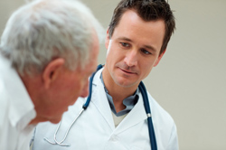Junger Arzt und älterer Patient