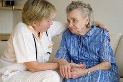 Ärztin legt Arm um ältere Patientin